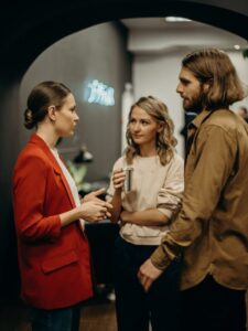 Three colleagues having a discussion in a modern office setting.